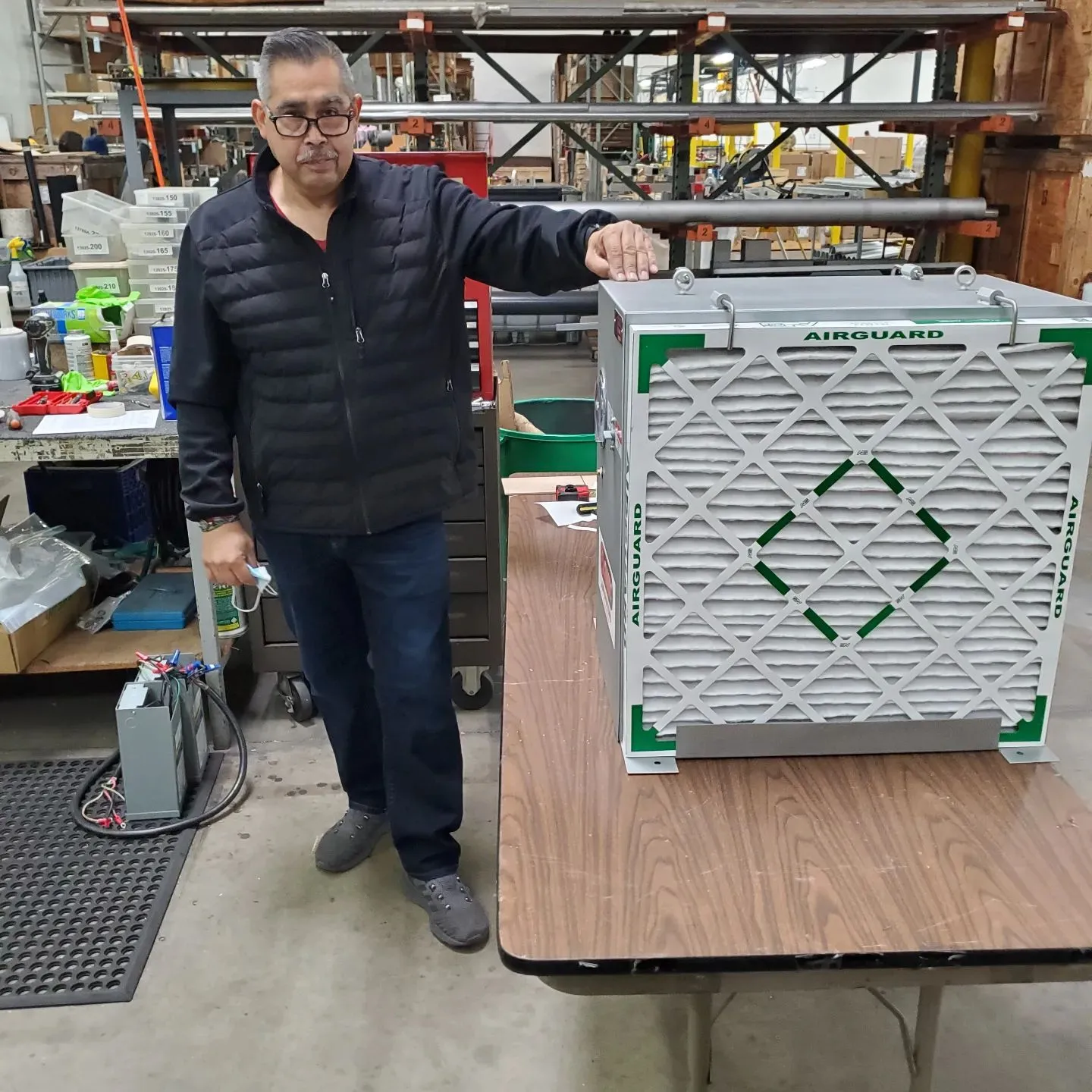 Sonic Air Systems team member standing beside an industrial air equipment unit in the workshop.