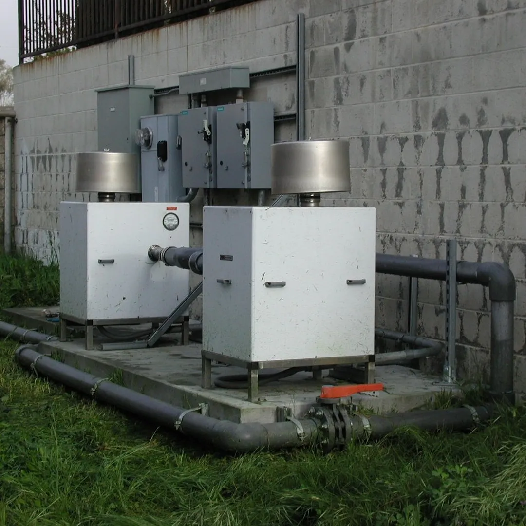 Outdoor industrial blower units connected to ductwork.