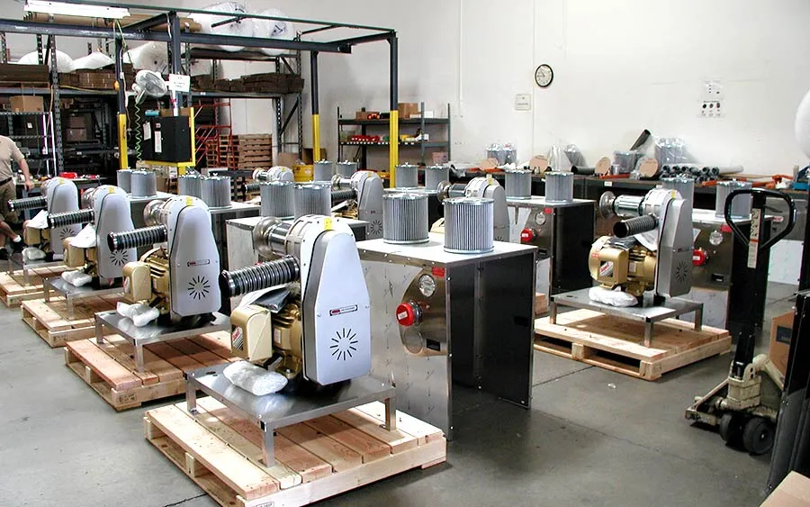 Rows of newly assembled industrial blower units on pallets inside Sonic Air Systems' production facility.
