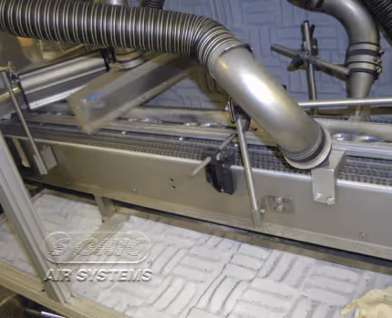 Rotary air knife system drying precision parts on a conveyor